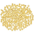 A pile of small, shiny gold round beads arranged in a circular shape on a plain white background.
