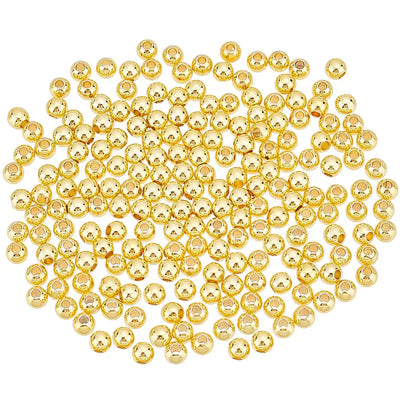 A pile of small, shiny gold round beads arranged in a circular shape on a plain white background.