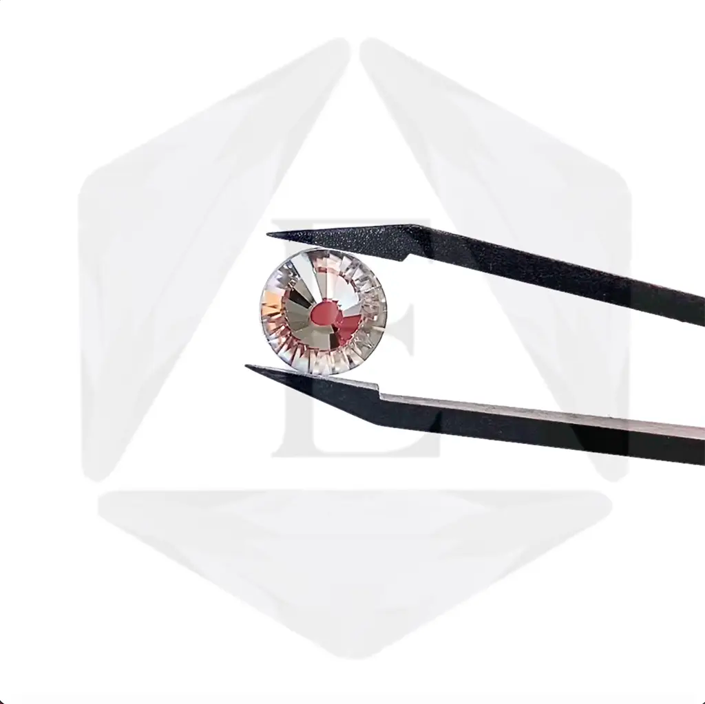 Estella rhinestone held in tweezers being rotated with the estella logo in the background