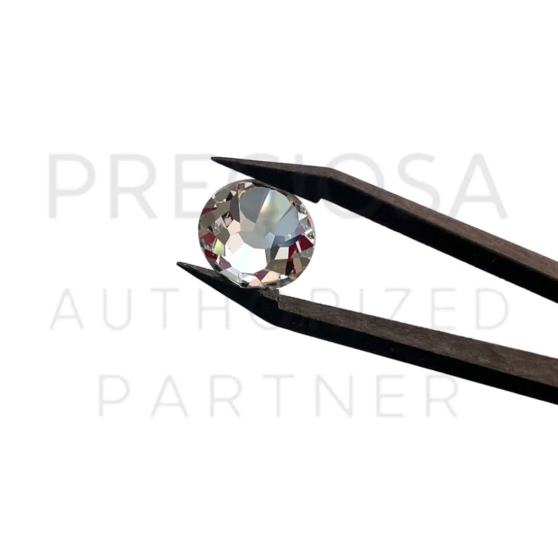 Preciosa flatback crystal sparkling in tweezers with the Serinity logo in the background