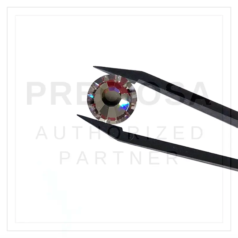 Preciosa flatback crystals held in tweezers and being rotated with a white background