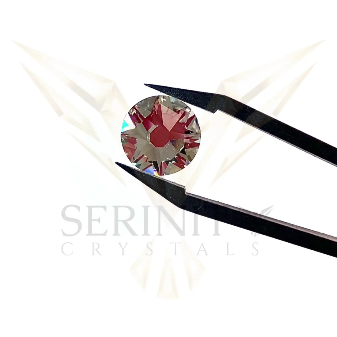 serinity flatback crystal sparkling in tweezers with the Serinity logo in the background